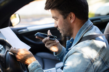 a man with a phone in the car