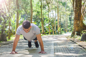 good looking man doing push ups in the forest