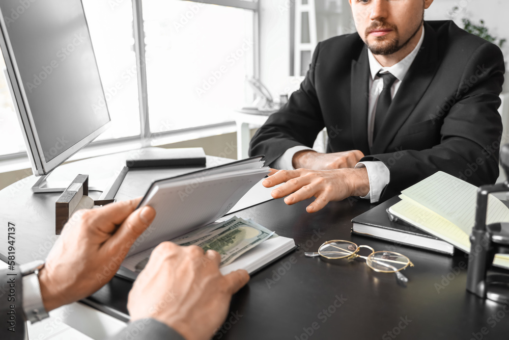 Man putting bribe in notebook at table, closeup