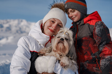 Poster - Mother, son and shih tzu dog on winter mountains background