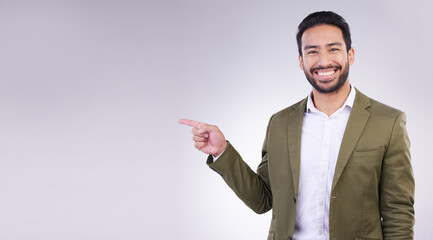Poster - Happy businessman, pointing and mockup for product placement, marketing or advertising against a white studio background. Employee man with smile showing point of advertisement, news or notification