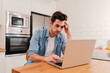 © Jose Calsina - Caucasian man freelancer entrepreneur overworked with burnout headache tired from stress having problems with the laptop computer, frustrated about his job sitting at home. High quality photo