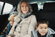 Portrait, road trip and grandmother travel with children or grandchildren and relax on a car ride in the backseat. Bonding, happy and grandma traveling with kids or grandkids on a journey