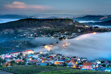 Wall Mural - Da Lat City, Lam Dong Province, Vietnam - Da Lat city in fog with brilliant lights in the night. The scene is magical