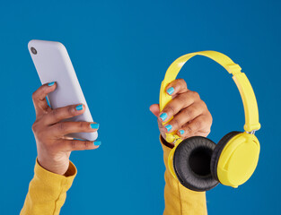 Sticker - Closeup, hands and smartphone with headphones, streaming music and audio against blue studio background. Zoom, hand and technology with cellphone, headset or radio with sounds, internet or connection