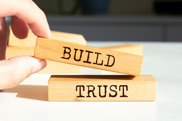 Wooden blocks with words 'BUILD TRUST'.