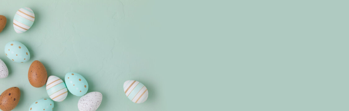 Fototapete - Easter frame of pastel colored eggs on light green background. Panorama, banner, flay lay, top view with copy space.