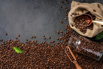 Wall Mural - Scoop of coffee beans in a bag on dark background. Top view of coffee in a cup. Copy space for text