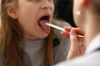 © H_Ko - Doctor conducts medical examination of sick red throat of little girl