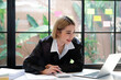 © Sucharat - Freelancer Happy business Asian woman in knitwear taking notes at laptop sitting at desk office, finance concept.