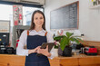 © PHAISITSAWAN - Portrait of a woman, a coffee shop business owner smiling beautifully and opening a coffee shop that is her own business, Small business concept..