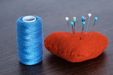 Demonstration of a pincushion and skeins of thread. Close-up