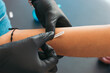 © ADDICTIVE STOCK - Anonymous artist in gloves applying stencil on arm of client in salon