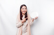 © Reezky - An Asian Muslim woman is fasting and hungry and holding utensils cutlery while looking aside thinking about what to eat