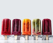 © henjon - Healthy colorful Vegan Fruit Popsicles Pieces of fruit inside. Studio Shot with Ice and white background. Copy Space. Illustrative generative AI.