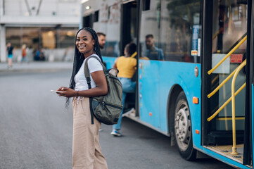 Wall Mural - Portrait of an african american woman waiting public transportation on a bus stop