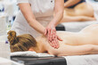 © Rokas - A professional masseuse gives a massage to a young, attractive woman. Body care. Massage therapist. Pretty woman relaxing in massage salon. Natural beauty close up shot
