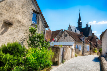 Canvas Print - Street in the Beautiful Village of Montresor, Loire, France, with St John the Baptist Collegiate Church