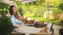 Woman Sitting On Swing Relaxing Outdoor In Garden. Authentic And Atmospheric Moment, Sun Light, Sunny Autumn Mood, Tranquility.