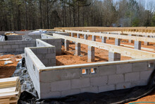 Cement blocks laid wall for foundation of house on construction site.
