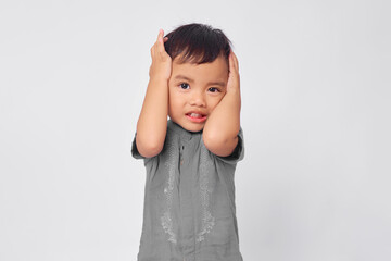 Wall Mural - Unhappy toddler Asian muslim boy holding hand in head isolated on white studio background