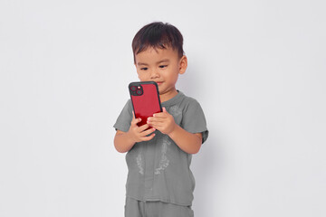 Wall Mural - Smiling toddler Asian muslim boy using mobile phone isolated on white studio background