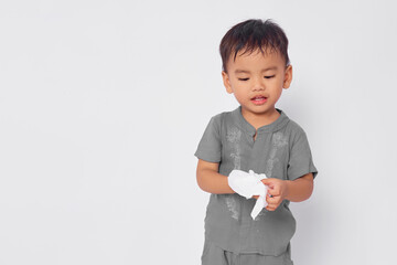 Wall Mural - Smiling toddler Asian muslim boy clean hands using tissue isolated on white studio background