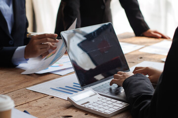 Teamwork with businessman analyzing cost graphs on table at conference room.