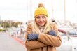 © luismolinero - Young pretty blonde woman wearing winter jacket at outdoors freezing