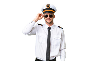 Wall Mural - Airplane pilot man over isolated background with glasses and happy