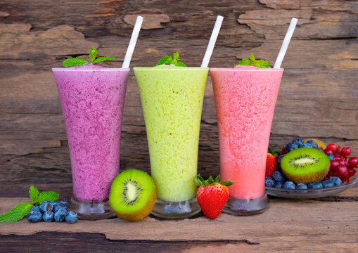 Fototapete - Kiwi strawberry and blueberry smoothies colorful fruit juice green purple and red milkshake blend beverage healthy high protein the taste yummy In glass drink episode morning on wood background.