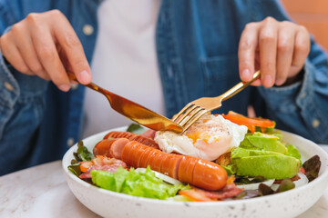 Wall Mural - Closeup image of a woman eating salad and drinking coffee in cafe