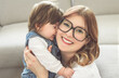 © Louis-Paul Photo - cute funny lady wear white t-shirt smiling and playing with baby girl inside the living room