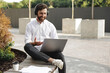 © Tymoshchuk - Man in headphones gesturing during online meeting on laptop