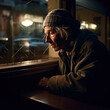 Generative AI - A homeless man sitting at a window looking out at the street outside of him at night time, with a hat on, cinematic photography, a character portrait, american realism