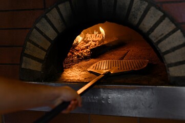 Sticker - pizza is put into the stone oven