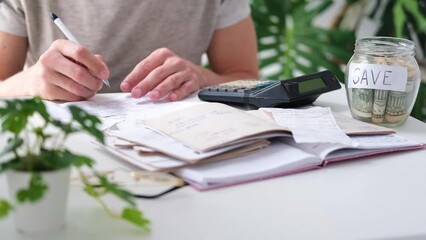 Wall Mural - a man counts a bill on a calculator on the table. payment of utility services. saving energy and mon