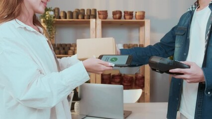 woman customer using QR code payment via smartphone for paying at shop