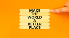 Make A Better World Symbol. Concept Words Make The World A Better Place On Wooden Stick. Beautiful Orange Table Orange Background. Businessman Hand. Business Make A Better World Concept. Copy Space.