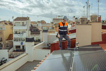 Wall Mural - Technical engineer installs photovoltaic energy cells on a city house roof. Worker tests urban household solar panels with multimeter during maintenance revision. Alternative energy. Horizontal