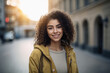 © aicandy - Confident woman with natural curly hair and a bright smile standing on a city street, generative ai
