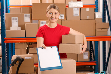 Canvas Print - Post office worker with parcels and clipboard near rack indoors