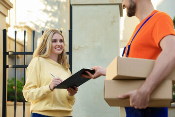 Poster - Woman signing order receipt outdoors. Courier delivery