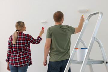 Wall Mural - Couple painting wall in apartment during repair, back view