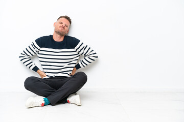 Wall Mural - Young man sitting on the floor isolated on white background suffering from backache for having made an effort