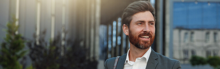 Smiling Businessman in suit going home after long working day and using phone