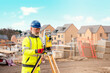 © Iryna - Surveyor builder site engineer with theodolite total station at construction site outdoors during surveying work