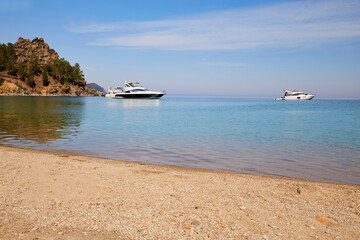 Wall Mural - Picturesque summer landscape. Yachts in a bay with turquoise water color. Coniferous forest. Holidays on the seashore.