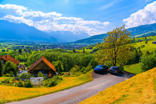 Gray Car And Brocken Car On The Road Near Wooden Cottage Houses On Green Fields, Grabs, Werdenberg, St. Gallen Switzerland
