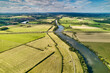Der Fluss Saône schlängelt sich durch die Landschaft bei Laperriere (F). Felder und Ackerflächen ziehen sich bis zum Horizont.